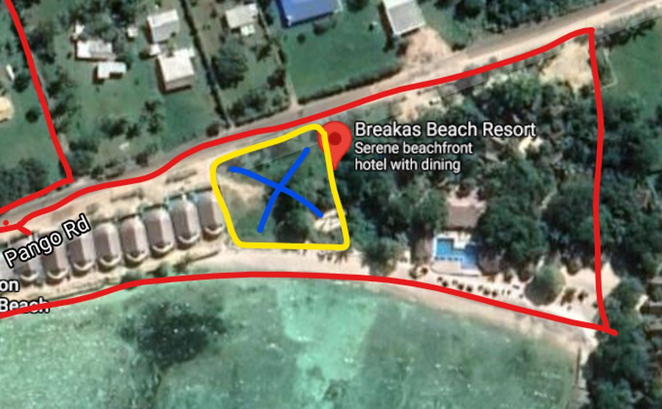 Aerial view of Pango Road and the lagoon with the vacant Butterfly Landing lot outlined in yellow between a row of beach farés and the resort pool